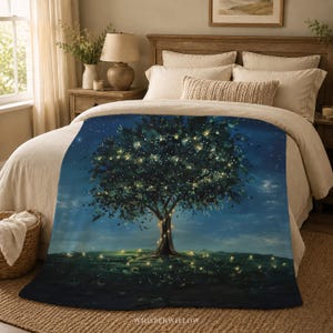 May include: A plush throw blanket featuring a dark blue night scene with a large tree illuminated by glowing yellow fairy lights. The tree is centered against a deep blue sky, with matching soft yellow lights scattered across the dark ground below.
