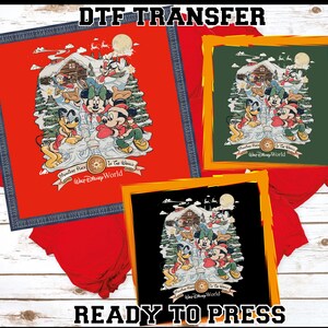 May include: DTF transfer featuring a winter scene with Mickey and Minnie Mouse, Pluto, and other Disney characters. The design is framed in red, green, and black, with the text "Ready to Press".