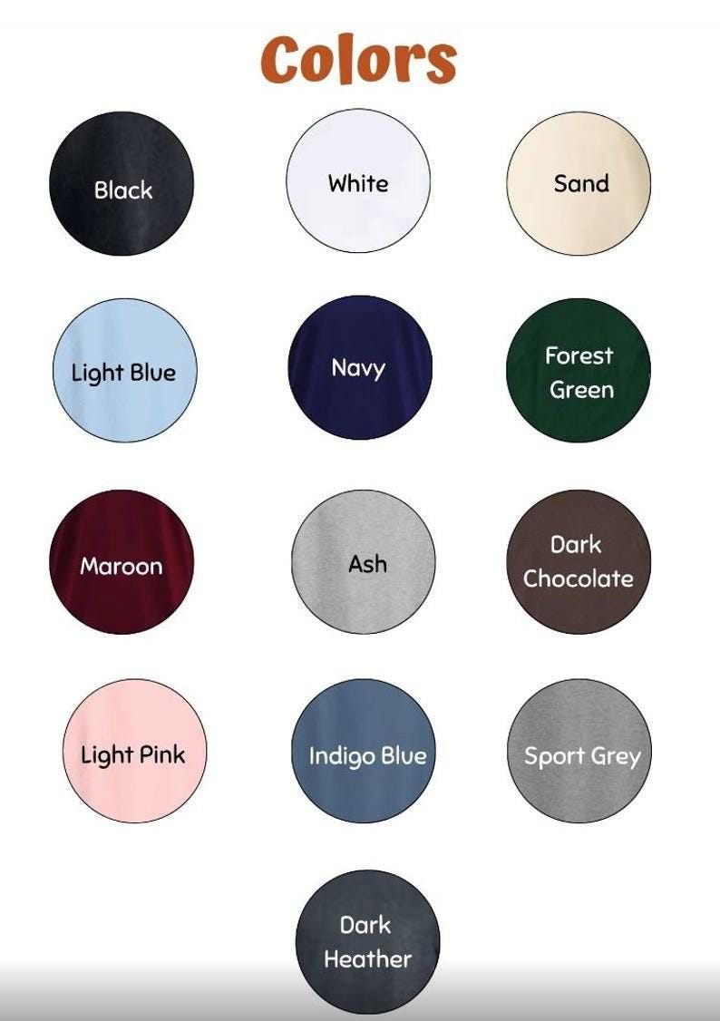 May include: Image displaying a color chart with various fabric colors. The chart includes circles labeled with colors such as Black, White, Sand, Light Blue, Navy, Forest Green, Maroon, Ash, Dark Chocolate, Light Pink, Indigo Blue, Sport Grey, and Dark Heather.