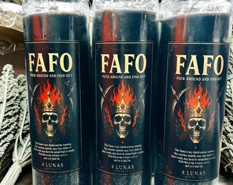 May include: Three tall cylindrical glass candles filled with dark wax. Each label features the text FAFO and FUCK AROUND AND FIND OUT above a graphic of a skull wearing a crown surrounded by flames, with the text 4 LUNAS BOTANICA at the bottom.