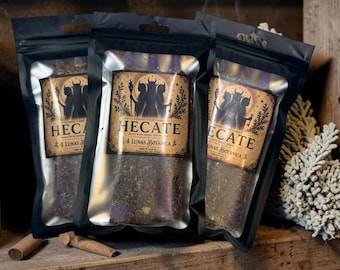 May include: Three black resealable pouches containing purple chime candles coated in dried herbs. Each pouch features a tan label with the text HECATE, 4 LUNAS BOTANICA, and an illustration of a three-headed figure holding a torch and a key.