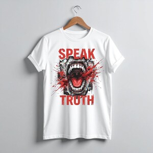 May include: A white short-sleeve t-shirt featuring a graphic print of an open mouth with sharp teeth, surrounded by red paint splatter effects and the text "SPEAK TRUTH" in bold red capital letters centered on the front of the garment.