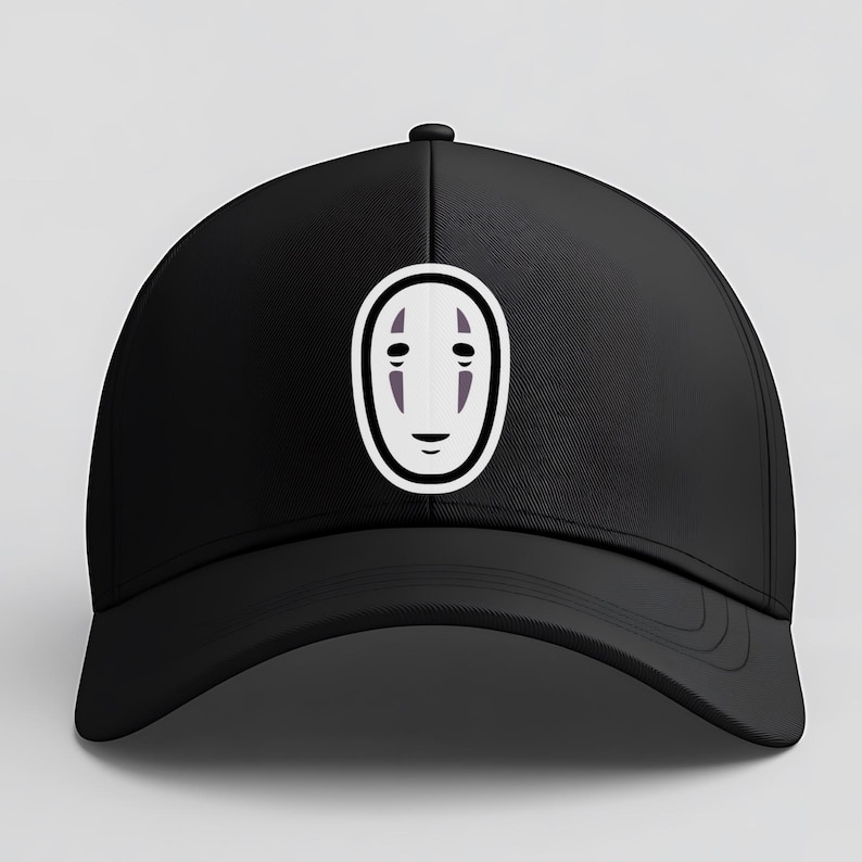 May include: Black baseball cap featuring a white and purple graphic of a character's face from the animated film, Spirited Away. The cap has a curved brim and a button on top.