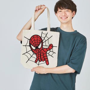 Peut inclure: Un sac fourre-tout cr&egrave;me avec un motif de Spider-Man rouge et une toile d'araign&eacute;e noire. Le super-h&eacute;ros est dans une pose dynamique, la main tendue. Le sac a deux anses et est fait d'un tissu robuste.