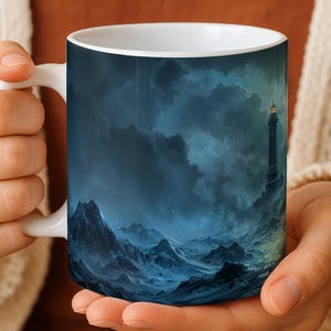 May include: White ceramic mug featuring a dramatic seascape with a lighthouse under a stormy sky. The design includes dark blue mountains and turbulent waves, creating a moody and atmospheric aesthetic. The mug is held by a person.