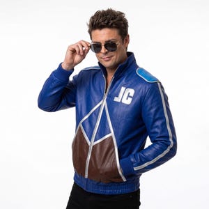 May include: A blue leather jacket with brown accents and silver trim. The jacket features the initials "JC" on the chest and a zipper closure. The jacket has a stand-up collar and ribbed cuffs and hem.