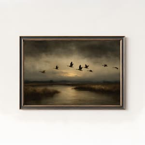 Peut inclure: Peinture de paysage encadrée représentant un vol d'oies au-dessus d'un marais au crépuscule. L'œuvre présente un ciel sombre et orageux avec un soupçon de soleil perçant les nuages. La palette de couleurs est dominée par des bruns, des gris et des ors sourds.