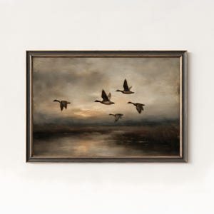 May include: An antique-style framed painting depicts a flock of ducks in flight over a body of water. The artwork features a muted color palette of browns, grays, and yellows, with a focus on the birds' silhouettes against a cloudy sky. The painting evokes a sense of tranquility.