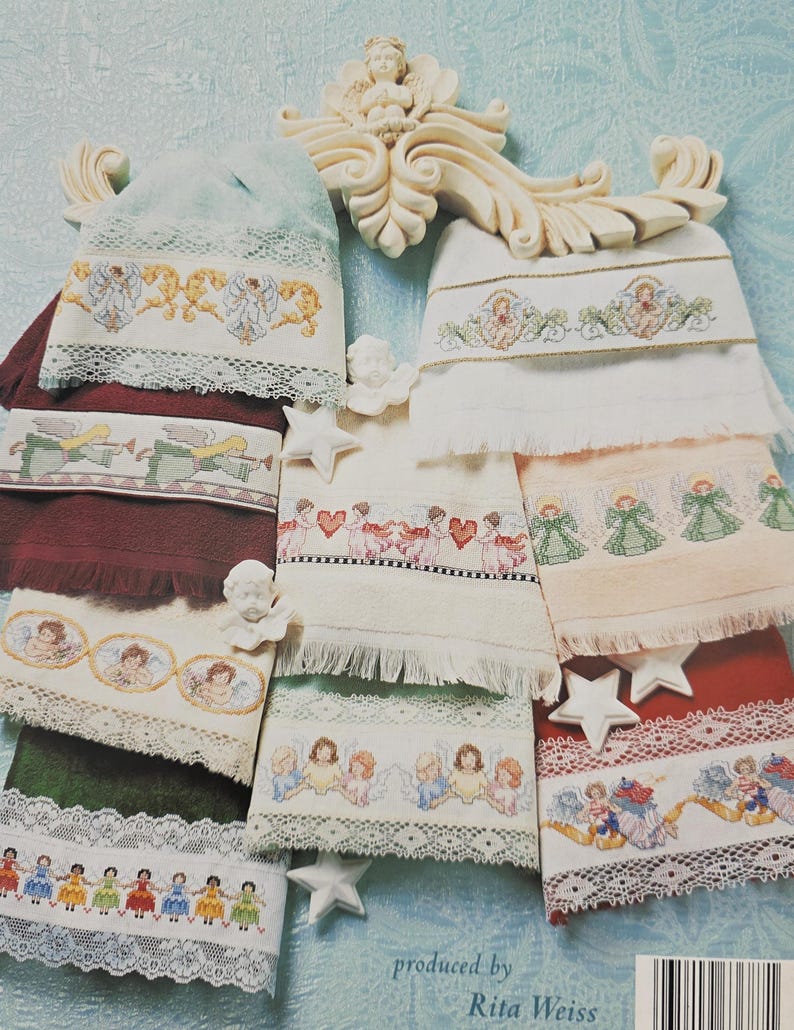 Peut inclure: Une collection de serviettes brod&eacute;es avec des motifs d'anges et de ch&eacute;rubins. Les serviettes pr&eacute;sentent diverses couleurs, dont le blanc, le vert et le bordeaux, avec une bordure en dentelle. Certaines serviettes ont des d&eacute;corations en forme d'&eacute;toile. Le texte "produced by Rita Weiss" est visible.