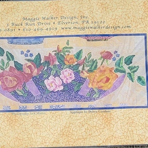 May include: Roseville Block of the Month #11 Zephyr Lily Boat Console 1940 with Gypsy Carnival and Joseph's Coat Roses applique pattern. The design features a purple boat filled with colorful roses and leaves.