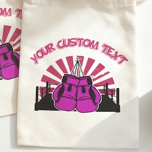 May include: Off-white drawstring bag with a graphic of purple boxing gloves hanging in front of a pink and red sunburst design. The text "YOUR CUSTOM TEXT" is arched above the gloves in pink.