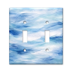 May include: A double light switch wall plate featuring a watercolor-style pattern of blended light blue, dark blue, and white brushstrokes. The rectangular cover includes two vertical rectangular cutouts for switches and four circular screw holes.