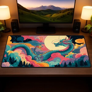 May include: A rectangular mouse mat with a colourful illustration of a teal dragon with red and yellow details, set against a backdrop of clouds and a full moon. The design includes pink, orange, and blue, creating a fantasy theme.