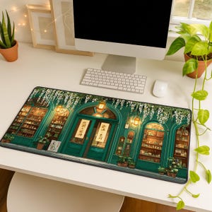 May include: A rectangular mousepad featuring a detailed illustration of a shop with a teal facade, lit by warm lights. The shop's entrance has two doors with Japanese text. The design includes hanging flowers and potted plants.