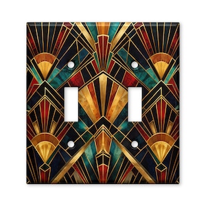 May include: A double light switch wall plate featuring a geometric pattern with gold, teal, red, and black lines and shapes. The rectangular plate has two vertical rectangular cutouts for switches and four circular screw holes in the corners.