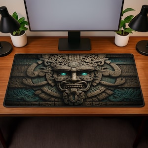 May include: A rectangular desk mat featuring a detailed stone-like relief carving of an ancient face with glowing cyan eyes. The design incorporates intricate geometric patterns and textures in shades of brown, tan, and deep teal, with a black border.
