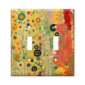 May include: A double toggle light switch plate featuring a vibrant, abstract floral pattern with a mix of yellow, orange, red, green, and black circular motifs and stylized flower shapes across the entire rectangular surface.