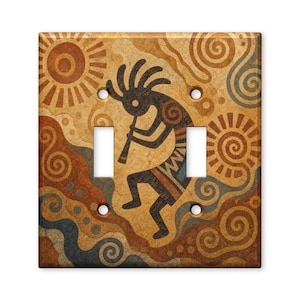 May include: A square double light switch wall plate featuring a brown and tan graphic of a Kokopelli figure playing a flute. The design includes sun motifs and swirling patterns with a textured, weathered appearance and four screw holes.