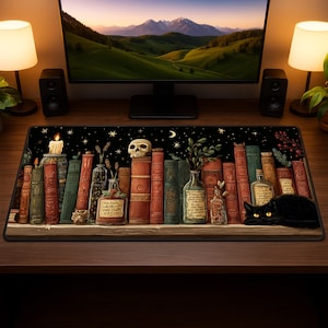 May include: A black desk mat featuring a bookshelf design with books, bottles, a skull, and a black cat. The background is a starry night sky. A lit candle is on the left side of the mat. The mat is on a wooden desk with a computer monitor.