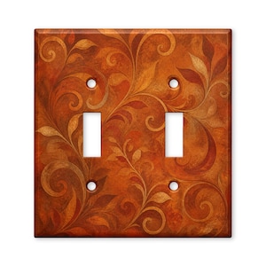 May include: A rectangular double light switch wall plate featuring a warm, autumnal color palette of burnt orange, deep copper, and golden brown tones. The surface is decorated with a continuous, flowing pattern of swirling leaves and vines.