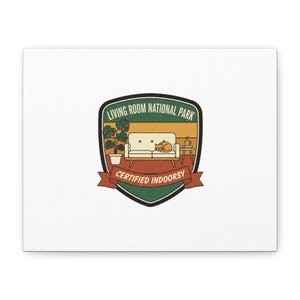 Könnte beinhalten: Leinwanddruck mit Retro-Grafik. Das Design zeigt ein schildförmiges Emblem mit dem Text "LIVING ROOM NATIONAL PARK" und "CERTIFIED INDOORSY". Das Emblem zeigt eine Wohnzimmerszene mit Sofa, Katze, Pflanze und Beistelltisch.