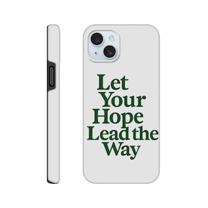 Puede incluir: Una funda de teléfono blanca con el texto "Let Your Hope Lead the Way" en verde oscuro. La funda tiene un recorte para la cámara y un botón lateral negro. La funda está diseñada para proteger el teléfono.
