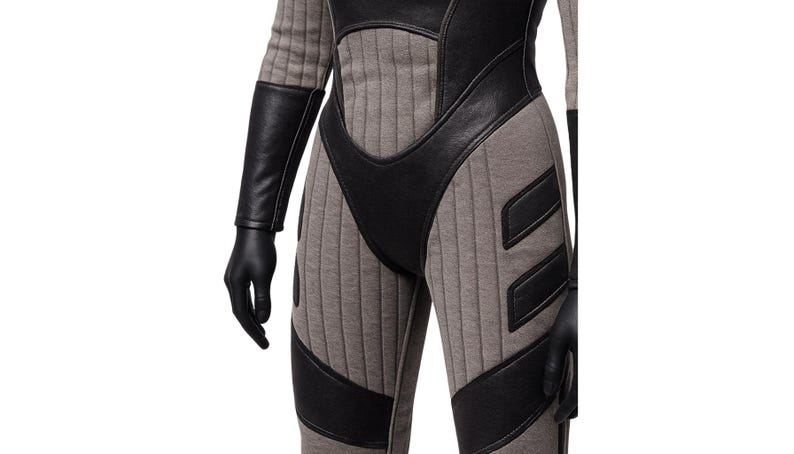 May include: A gray and black jumpsuit with a futuristic design. The suit features vertical ribbed panels in gray, contrasted by black leather-like accents on the shoulders, chest, and legs. Black gloves complete the look.