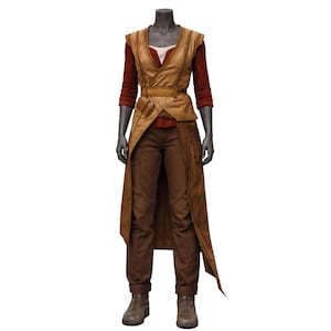 May include: A complete outfit on a mannequin. The ensemble includes a tan vest, a rust-colored long-sleeved shirt, brown pants, and matching boots. A brown belt and a long, flowing tan overcoat complete the look. The outfit is designed with a layered aesthetic.
