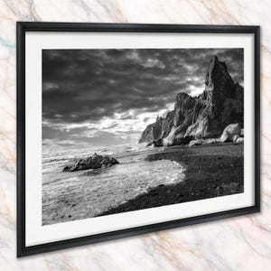 May include: A white ceramic mug with a black handle and the text "But First, Coffee" in a bold, black font. The mug is set against a neutral background, highlighting its simple design.