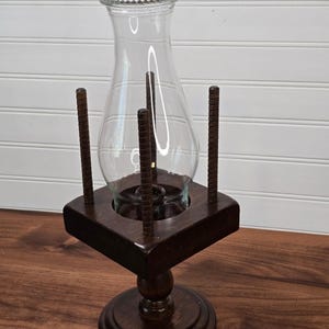 Vintage houten stormlantaarn met voetstuk, geschikt voor taps toelopende kaarsen.