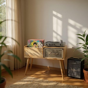 May include: A wooden record player stand with a built-in compartment for vinyl records. A gray turntable sits on top, with a Marshall speaker below. A black Marshall speaker is on the floor. The stand is in a room with natural light.