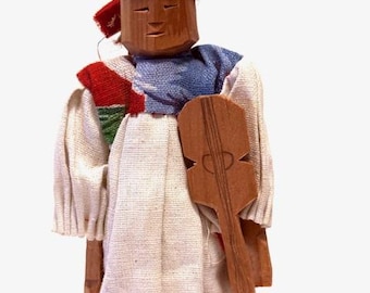 Antique folk art handcrafted wooden doll from Mexico with instrument.