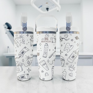 May include: A set of three ceramic mugs with a speckled, matte finish. The mugs are in shades of cream, light gray, and dark gray. Each mug has a simple, minimalist design, perfect for coffee or tea.