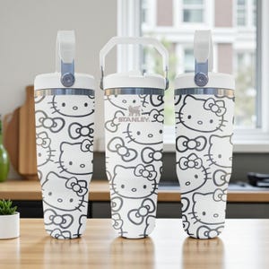 Peut inclure: Trois gobelets isothermes blancs avec un motif répétitif gris de Hello Kitty et de nœuds. Chaque gobelet possède un couvercle blanc avec une poignée de transport robuste et un bord métallique. Le gobelet central affiche le logo Stanley en gris.