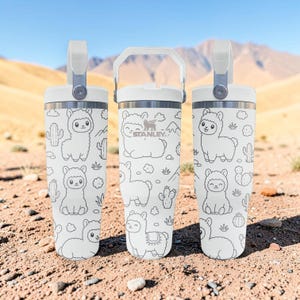Peut inclure: Trois gobelets en acier inoxydable blanc avec un motif répétitif de lignes noires représentant des lamas, des cactus et des petits nuages. Chaque gobelet possède un couvercle blanc avec une poignée robuste et la marque Stanley au centre.