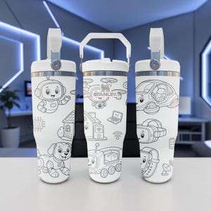 May include: Three white Stanley tumblers with a handle and a black and white line art pattern featuring robots, a drone, a house, a laptop, a robotic dog, a vehicle, headphones, a battery, and a satellite dish. The Stanley logo is printed on the center.