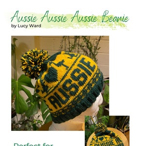 May include: A green and gold knit beanie with the text "AUSSIE" and a kangaroo design. The beanie has a pom-pom on top and is displayed on a mannequin head. The text "Aussie Aussie Aussie Beanie by Lucy Ward" is at the top.