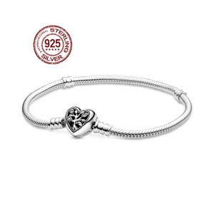May include: A sterling silver bracelet with a heart-shaped charm. The charm features a tree design and is connected to a snake chain bracelet. The bracelet is marked with "925 SILVER" and is a piece of jewelry.