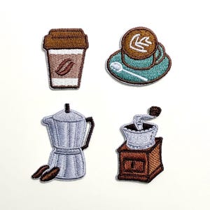 May include: Embroidered patches with coffee-related designs. The set includes a takeaway coffee cup, a cup and saucer, a stovetop espresso maker, and a coffee grinder. The patches are in brown, blue, and white.