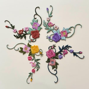 Puede incluir: Cuatro parches bordados con motivos florales que presentan un intrincado trabajo de hilo en tonos rojo, amarillo, rosa, morado y verde. Cada parche muestra una disposición única de flores, capullos y tallos curvos con texturas de hojas.