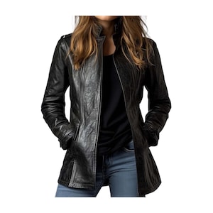 Puede incluir: Chaqueta de cuero negra con un acabado texturizado. La chaqueta tiene cuello alto, cierre de cremallera y bolsillos. La chaqueta de manga larga se lleva sobre una camiseta negra y vaqueros azules.