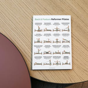 Może przedstawiać: Biała książka zatytułowana "Back & Posture Reformer Pilates" z ilustracjami ćwiczeń Pilates. Książka jest otwarta, wyświetlając r&oacute;żne ćwiczenia z instrukcjami. Książka leży na drewnianej powierzchni.