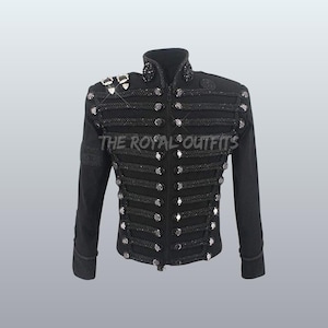 Puede incluir: Chaqueta negra de estilo militar con botones plateados y detalles decorativos de cuerda. La chaqueta tiene un cuello alto y adornos en los hombros. El texto "THE ROYAL OUTFITS" está impreso en la chaqueta.