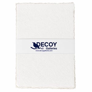 May include: A stack of white handmade paper with deckled edges, wrapped with a white band featuring a blue bird logo and the text "DECOY Galleries" and website address.