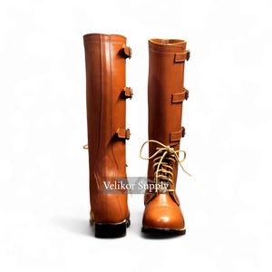 May include: A pair of tall, brown leather boots with multiple buckle closures and a lace-up front. The boots have a classic design, with a rounded toe and a sturdy sole. The boots are displayed against a white background.