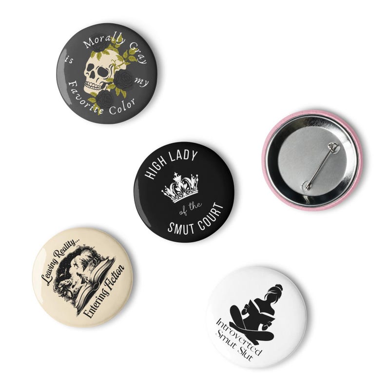 May include: A collection of five round pinback buttons. One button features a skull with roses and the text "Morally Gray is my favorite color." Another says "High Lady of the Smut Court." Other buttons have text and illustrations.
