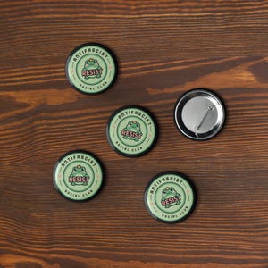 Puede incluir: Taza de cer&aacute;mica blanca con asa negra y la frase "But First, Coffee" en negro. La taza se muestra sobre un fondo borroso, sugiriendo un ambiente acogedor.