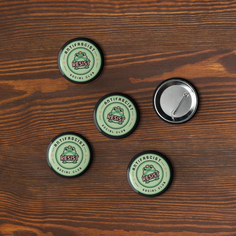 Puede incluir: Taza de cer&aacute;mica blanca con asa negra y la frase "But First, Coffee" en negro. La taza se muestra sobre un fondo borroso, sugiriendo un ambiente acogedor.