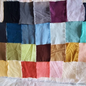 May include: A collection of 24 fabric swatches in various colors, including black, gray, blue, green, brown, yellow, red, pink, and white. The swatches are arranged in a grid pattern.