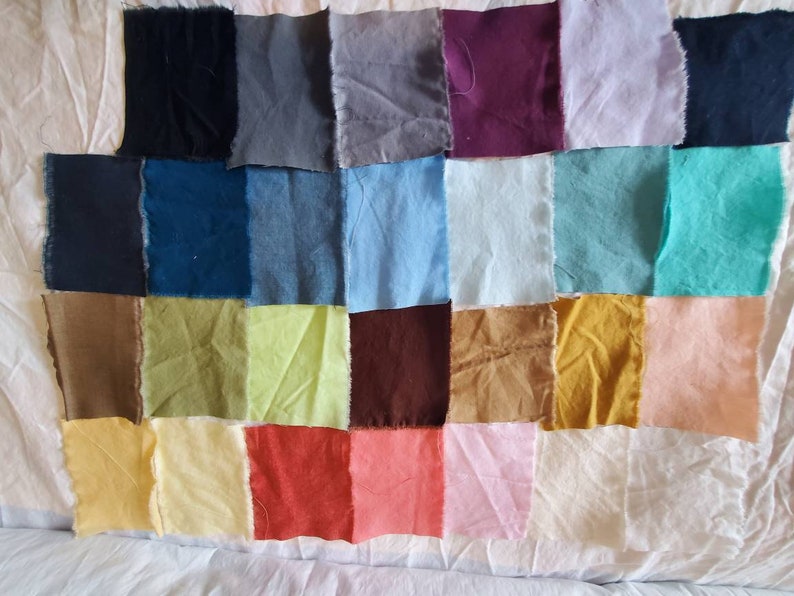 May include: A collection of 24 fabric swatches in various colors, including black, gray, blue, green, brown, yellow, red, pink, and white. The swatches are arranged in a grid pattern.